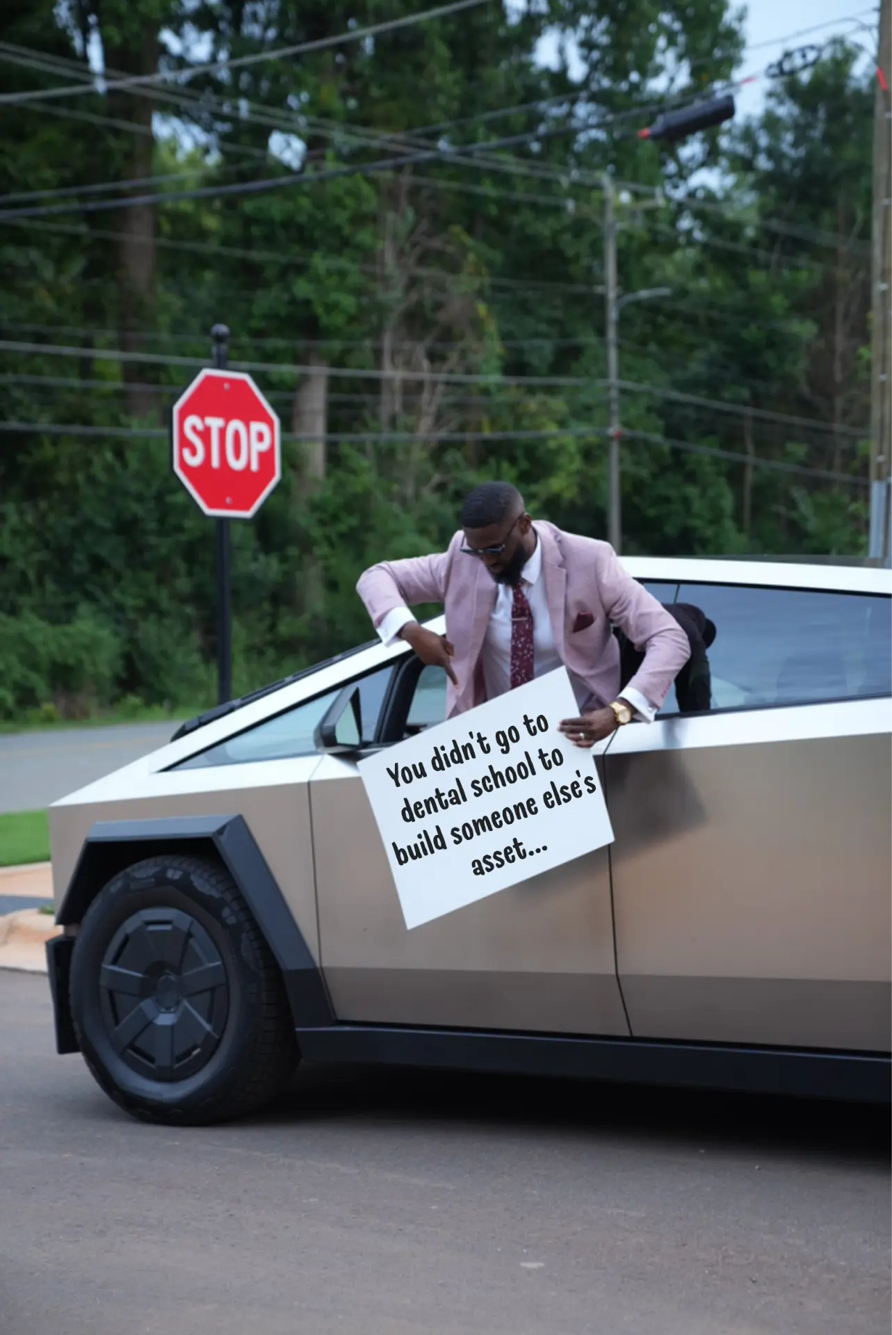 Kingsley Ifedi with a sign beside the practice truck